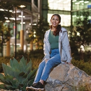 Kassandra Gomez sitting on rock in front of hospital